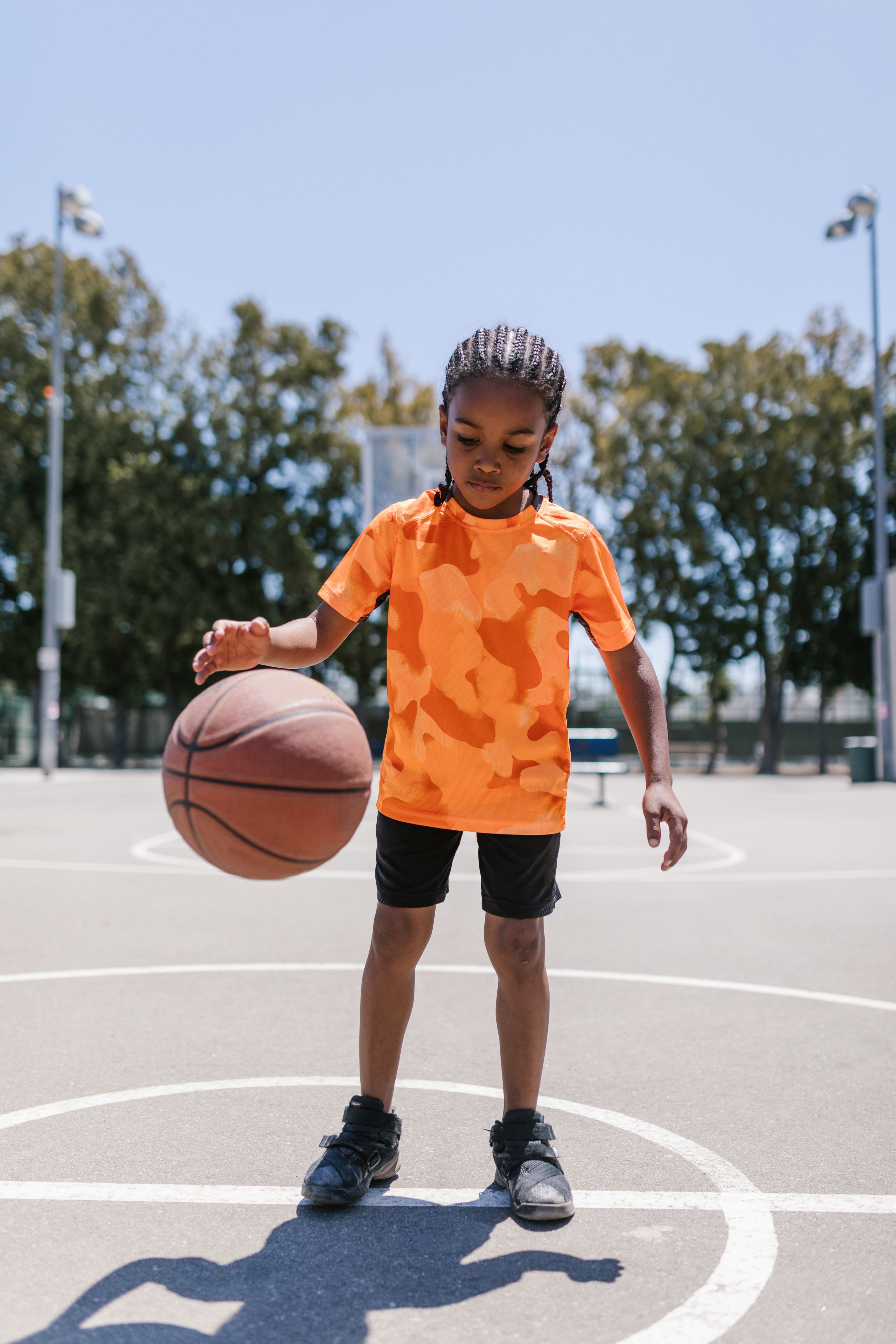 Young child dribbling on an outdoor basketball court