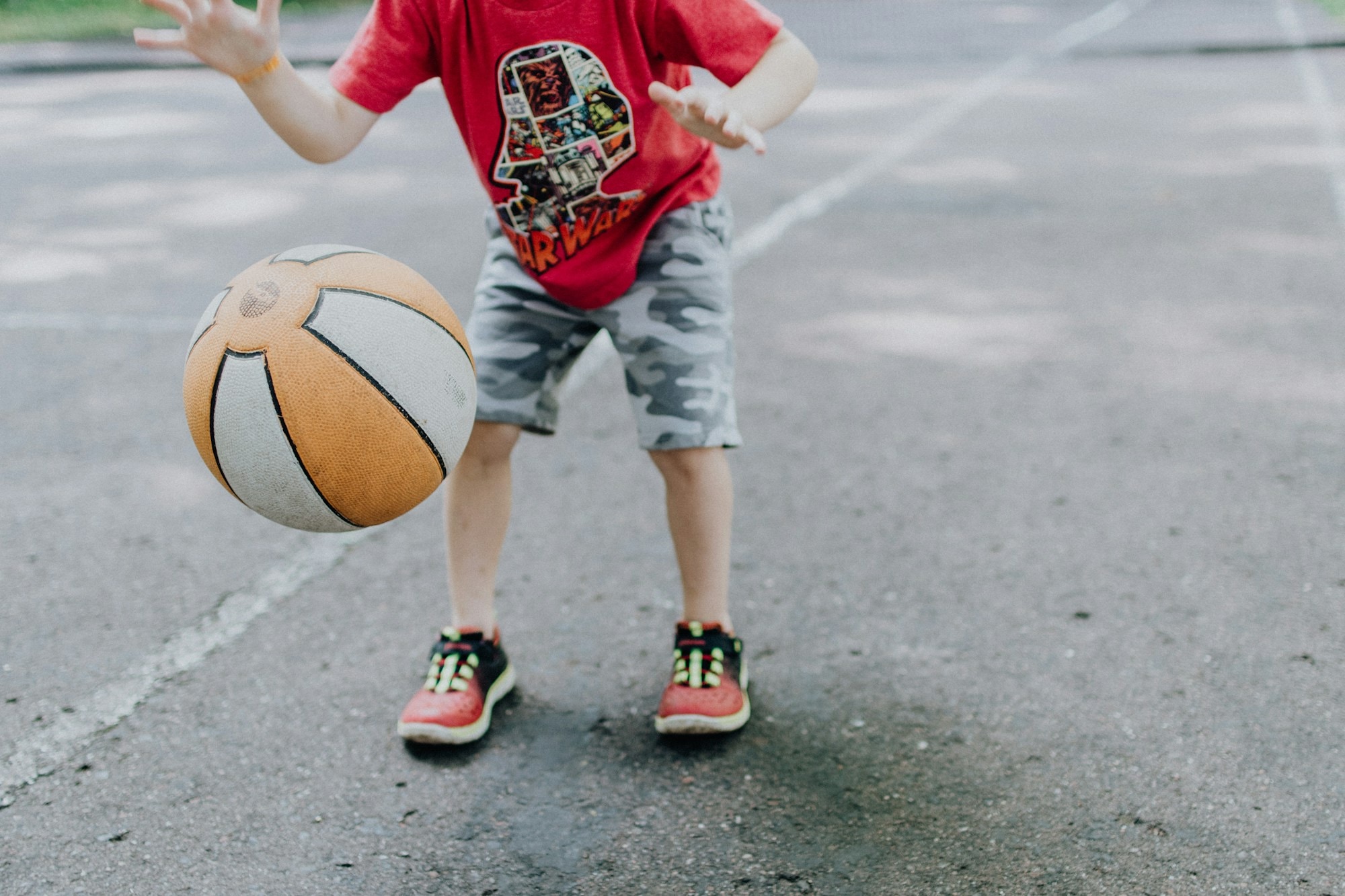 Young child dribbling a basketball outdoors