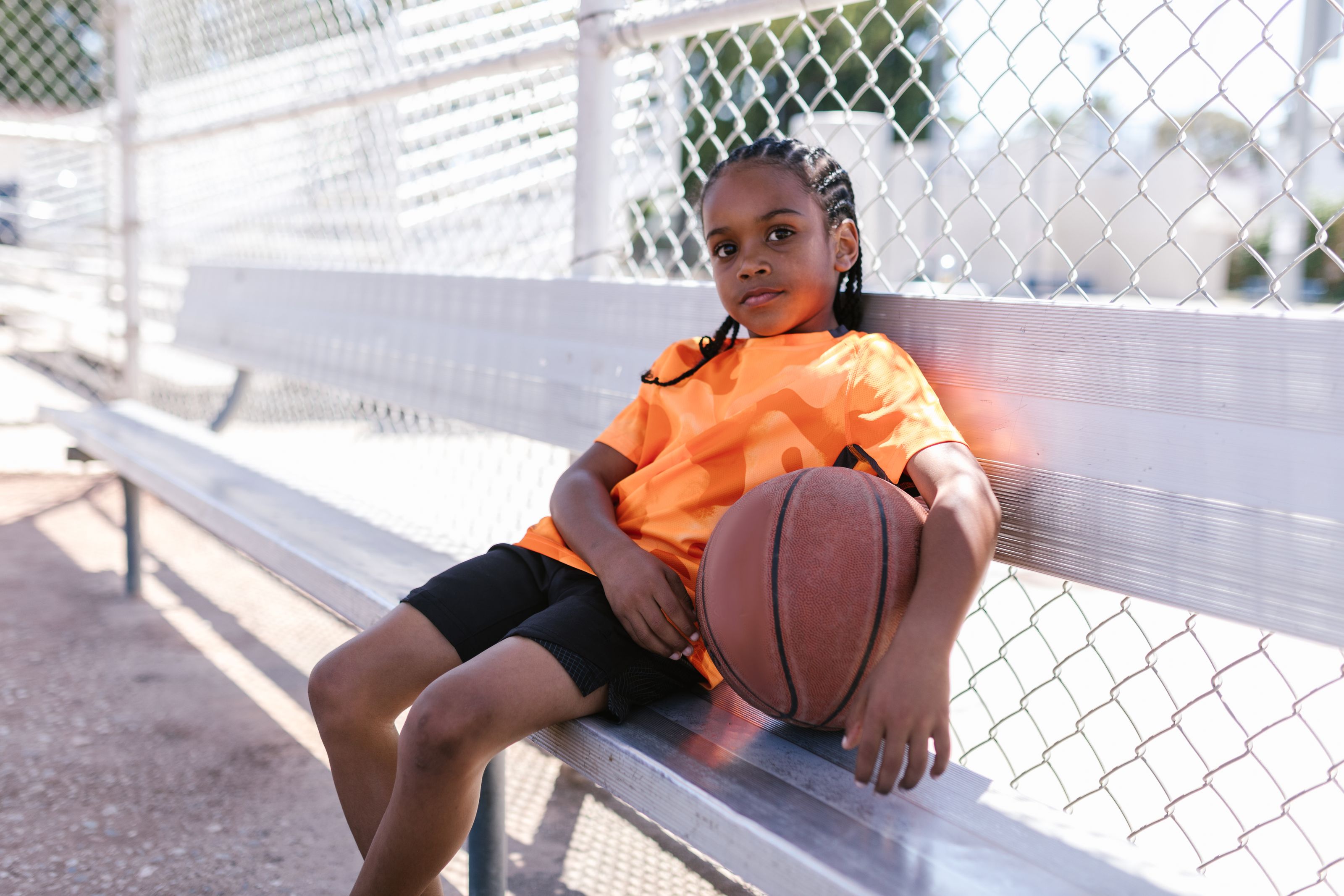 Young player sitting with a basketball